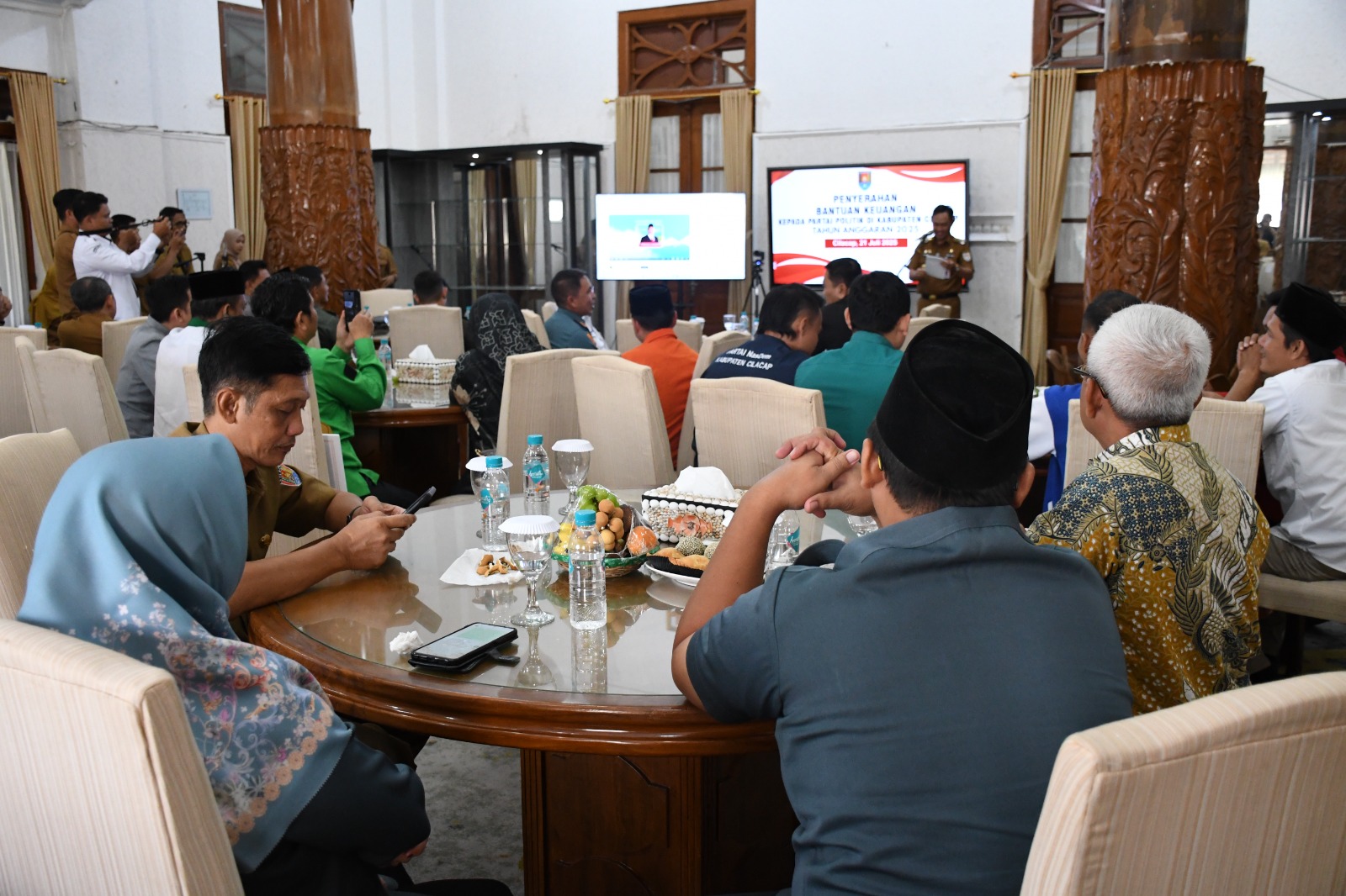 Ketua dan Anggota Bawaslu Cilacap; Soim Ginanjar (kanan) dan Nuryanti (kiri) menyaksikan penyerahan bantuan keuangan kepada delapan parpol tahun anggaran 2025 oleh Bupati Cilacap  di rumah dinas Bupati Cilacap, Senin (21/7/2025)/foto: Humas Bawaslu Cilacap